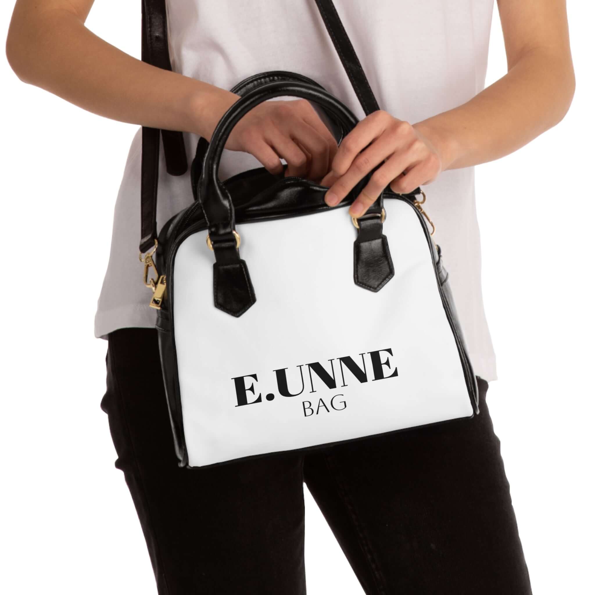 E.UNNE Classic Shoulder Handbag — Elegant White & Black Leather Tote being carried by a model.