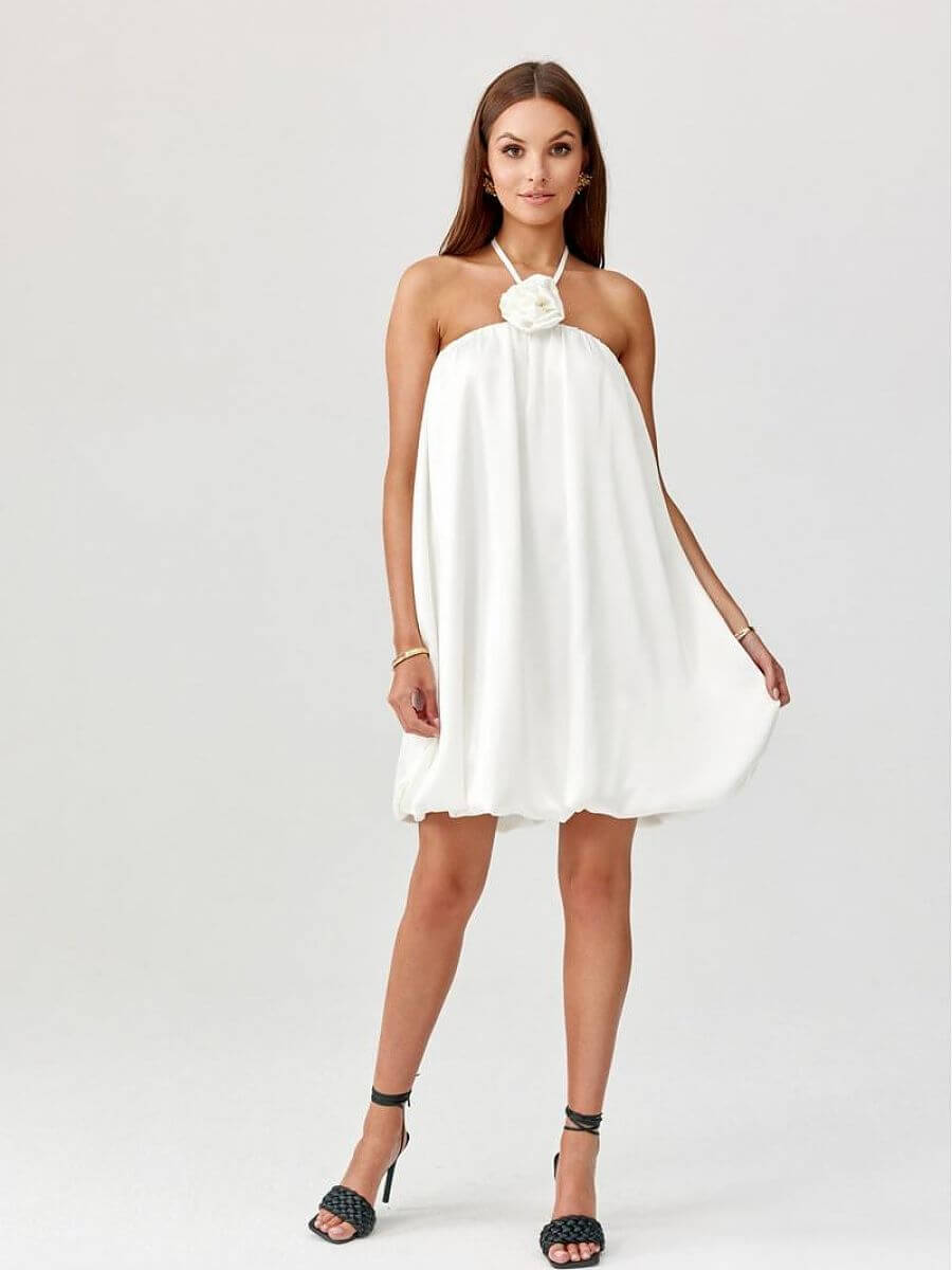 Model showcasing a bombshell cocktail dress with a floral detail, perfect for making a statement.