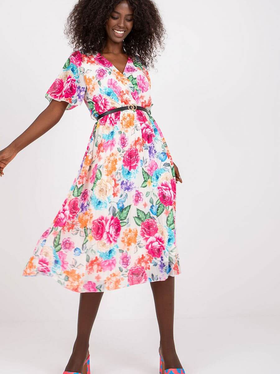 Model wearing a floral summer daydress with short sleeves, flared cut, and a belt against a white background.