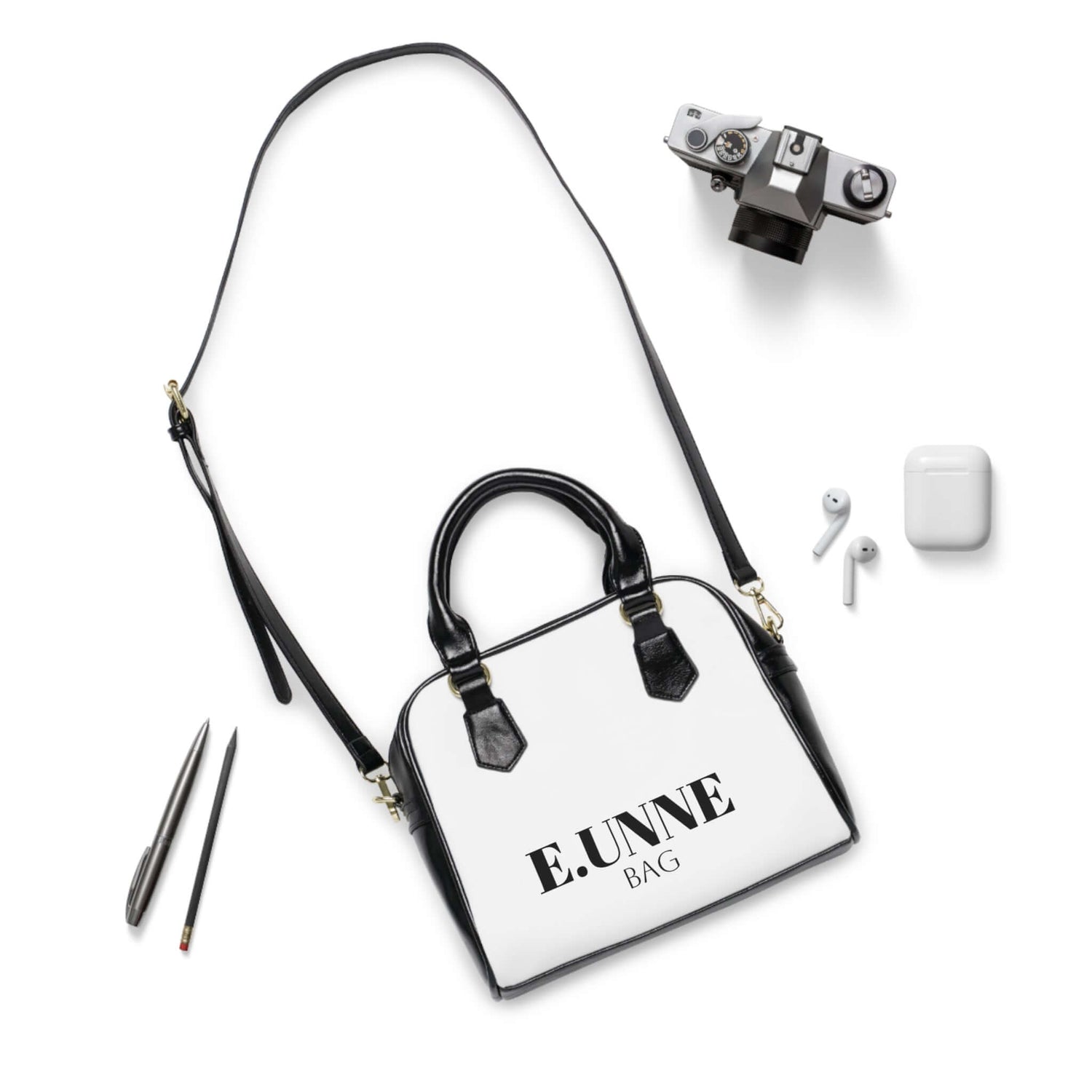 E.UNNE Classic Shoulder Handbag — Elegant White &amp; Black Leather Tote with accessories laid out.