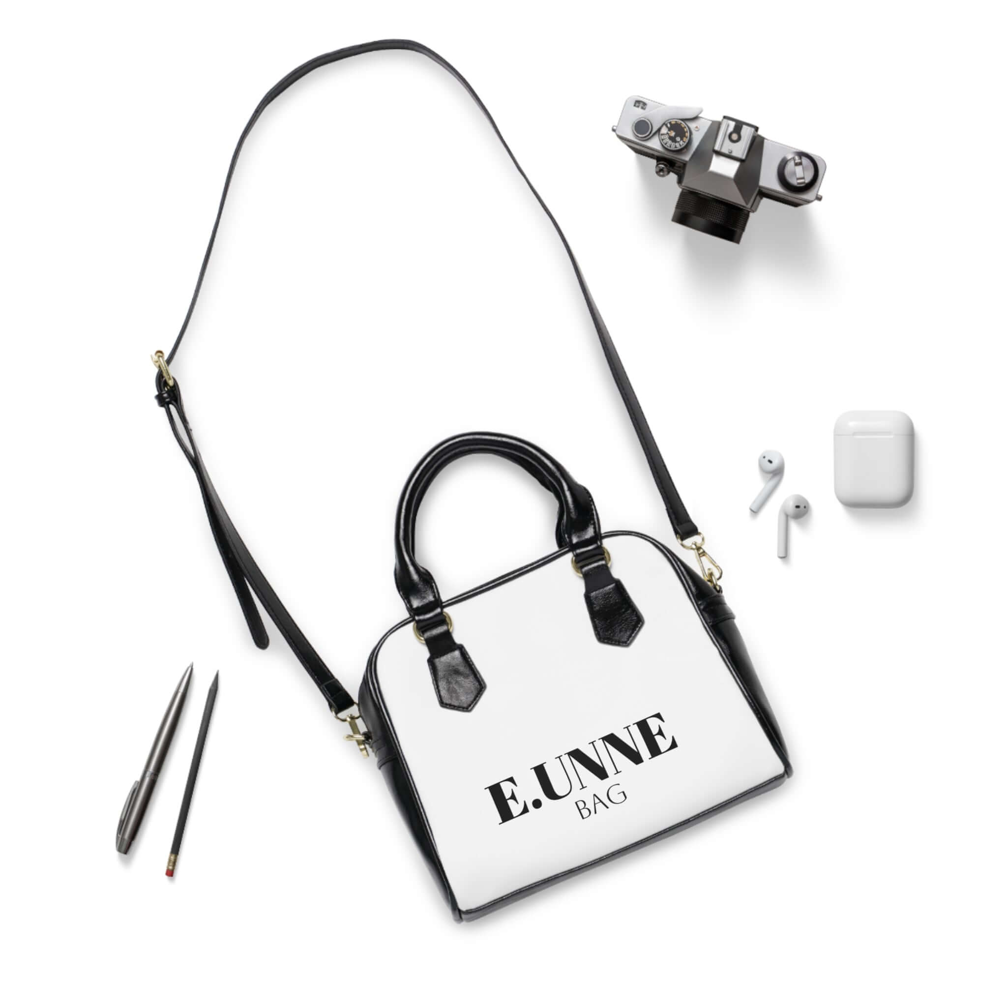E.UNNE Classic Shoulder Handbag — Elegant White &amp; Black Leather Tote with accessories laid out.