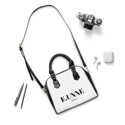 E.UNNE Classic Shoulder Handbag — Elegant White &amp; Black Leather Tote with accessories laid out.