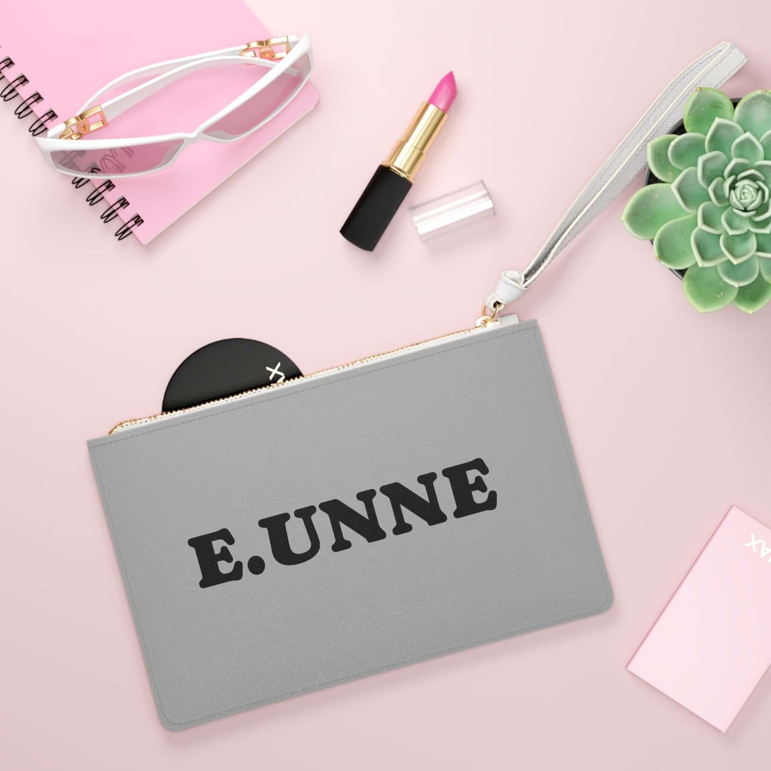 E.UNNE Clutch Bag — Elegant Evening &amp; Day Bag on a stylish flat lay with beauty products and accessories.
