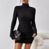 Elegant turtleneck knitted dress in black with ribbed texture, styled with a stylish handbag.