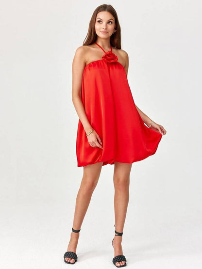 Model showcasing a bombshell cocktail dress with a floral detail in vibrant red fabric.