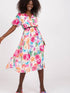 Model wearing a floral summer daydress with short sleeves, flared cut, and a belt against a white background.