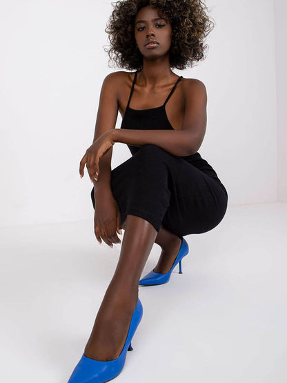 Model wearing a summer pencil dress with blue heels, showcasing a stylish summer look in a bright setting.