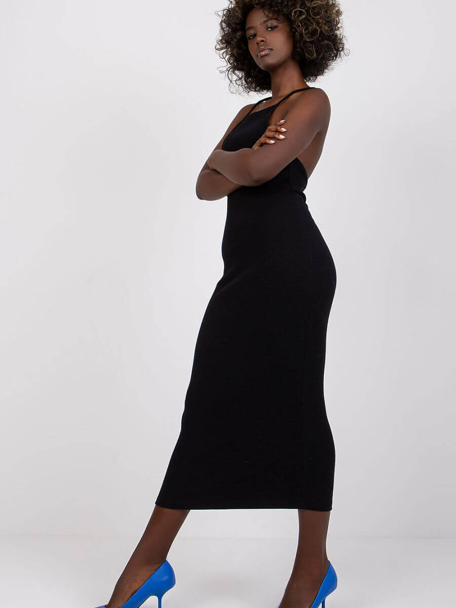 Model showcasing a summer pencil dress in black, featuring a fitted design and stylish blue heels, perfect for summer elegance.